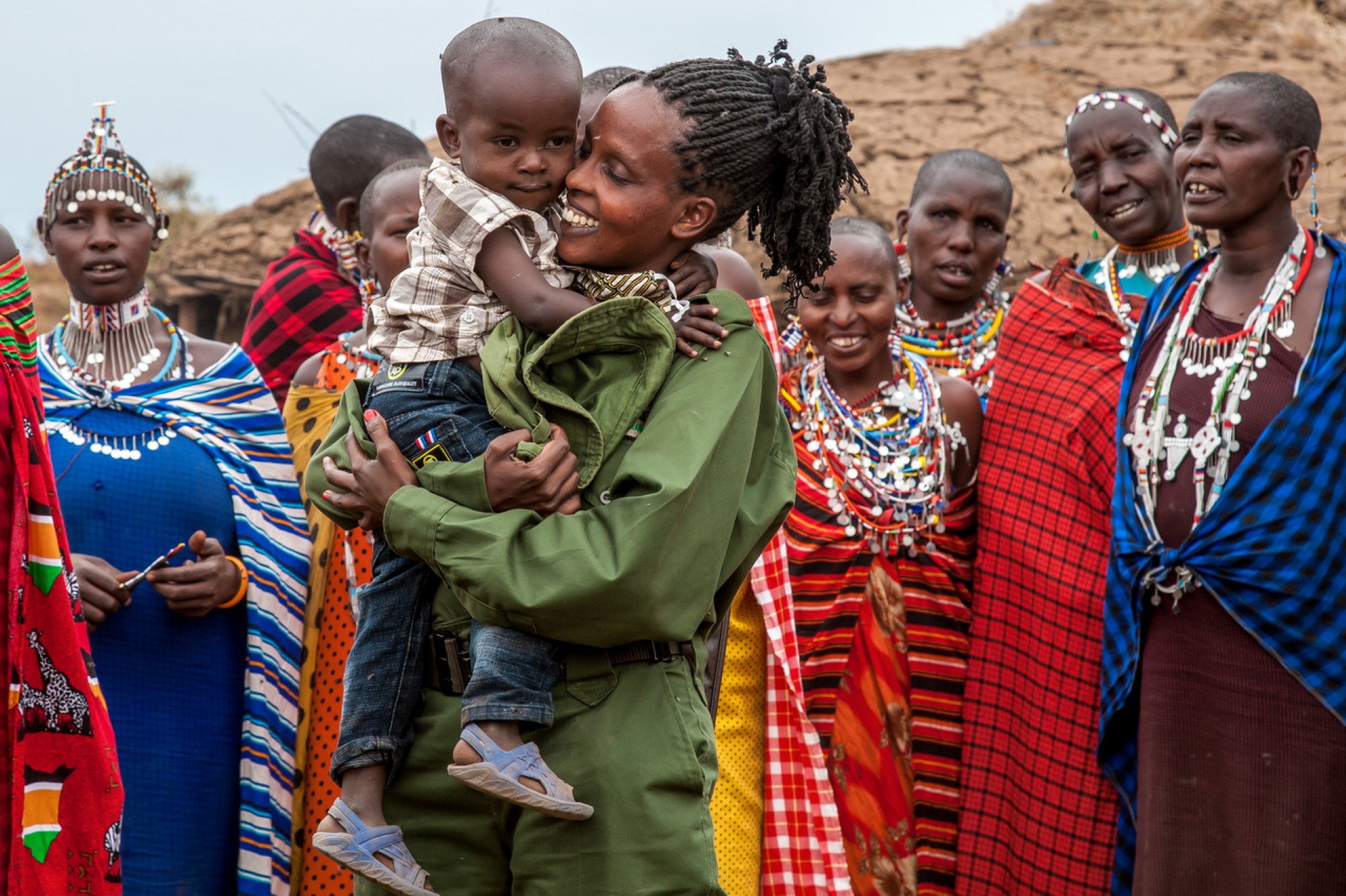 Team Lioness Rangerin Ruth Sekeita begrüßt ihren Sohn und die Frauen in ihrer Massai-Community. Photo Credit: Paolo Torchio | IFAW Team Lioness Rangerin Ruth Sekeita begrüßt ihren Sohn und die Frauen in ihrer Massai-Community. Photo Credit: Paolo Torchio | IFAW