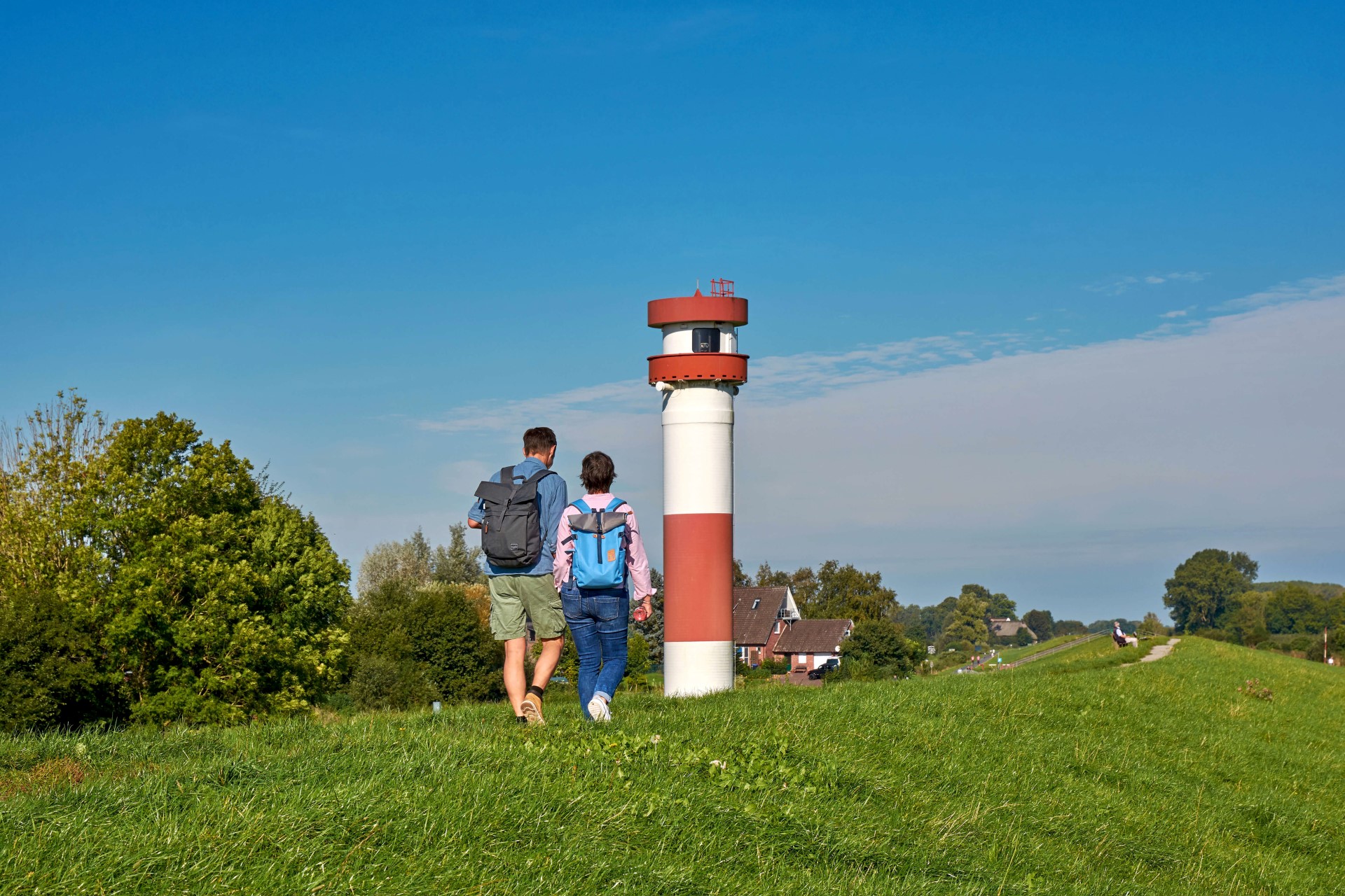 Idyllische Wanderung auf dem Deich: Der Leuchtturm ist das Wahrzeichen der Elbinsel Krautsand. Foto: djd | Tourismusverband Landkreis Stade
